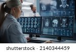 Small photo of Medical Hospital Health Care Lab: Camera Captures Professional Neuroscientists Analysing CT Scan Finding Cure for Sick Patient and Female Neurologists Using Computer with Brain Scan MRI Images