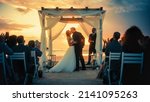 Small photo of Beautiful Bride and Groom During an Outdoors Wedding Ceremony on an Ocean Beach at Sunset. Perfect Venue for Romantic Couple to Get Married, Exchange Rings, Kiss and Share Celebrations with Friends.
