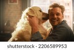 Small photo of Happy Handsome Young Man Play with His Dog at Home, Gorgeous Golden Retriever. Attractive Man Sitting on a Floor. Excited Dog Licking the Owner that Teases the Pet. Have Fun in the Stylish Apartment.