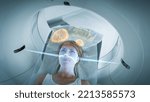 Small photo of Female Patient Lying on a CT or PET or MRI Scan Bed, Moving Inside the Machine While it Scans Her Brain and Vital Parameters. AR Concept with Visual Effects In Medical Lab with High-Tech Equipment.