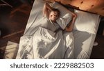 Small photo of Top View Home: Handsome Young Man Sleeps in His Bed, Sun Shines on Him, He Opens Eyes and Greets New Sunny Day at Home. Joyful Waking Up of a Guy who is Ready for Productive Day. Top Down Above Shot