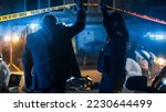 Small photo of Team of Two Multiethnic Police Officers Working on Profiling a Killer on the Loose. Detectives on Duty at Night Solving Crime to Bring a Violent Murderer to Justice. Police Car and Paramedics on Site