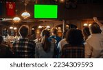 Small photo of Group of Multicultural Friends Watching a Live Sports Match on TV with Green Screen Display in a Bar. Happy Fans Cheering and Shouting, Celebrating When Team Scores a Goal and Wins the Tournament.