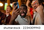 Small photo of Portrait of Two Excited Diverse Friends Holding a Smartphone, Celebrate Winning a Sports Bet on Their Favorite Soccer Team. Lively Successful Emotions When Football Team Scores a Winning Goal.