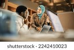 Small photo of Two Coworkers Collaborating and Celebrating Their Accomplishment in a Modern Office. Muslim Female Trainer Using Laptop to Onboard a Black Male Customer Support Agent and Answering His Question.