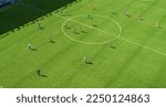 Small photo of Aerial Top Down View of Soccer Football Field and Two Professional Teams Playing. Passing, Dribbling, Attacking. Football Tournament Match, International Competition. Flyover Whole Stadium Shot.