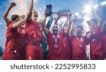 Small photo of Football Finals Tournament Winning Team Celebrates Victory Cheering and Lifting Trophy Prize on Stadium. Happy Soccer Players Champions of International Championship Cup. Fireworks Shot.