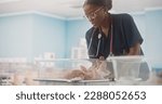 Small photo of Maternity Hospital Ward: Friendly Black Head Nurse Taking Care of a Newborn Baby. African Pediatrician Putting the Infant Back in the Bassinet During a Checkup in Nursery