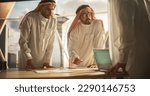 Small photo of Successful Muslim Businessmen in White Traditional Outfits Having an Office Meeting, Negotiating and Talking About Financial Opportunities. Using Laptop. Saudi, Emirati, Arab Businessman Concept.