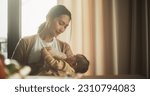 Small photo of Portrait of Beautiful Asian Mother Feeding Milk to her Infant Using a Baby Bottle at Bright Home. Young Woman New to Motherhood Bonding with her Child and Enjoying an Affectionate Family Moment.
