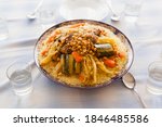 Small photo of Foodie design elements friday gathering family size delicious couscous plated with stew, vegetables and beef with spoons. Moroccan gastronomy essentials for Ramadan and holidays with copy space.