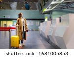Woman with luggage stands at almost empty check-in counters at the airport terminal due to coronavirus pandemicCovid-19 outbreak travel restrictions. Flight cancellation.Quarantine all over the world