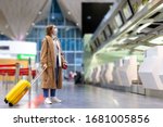 Woman with luggage stands at...