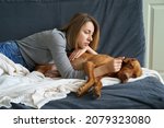 Worried woman taking care of weakening old dog at home. Poor animal suffer from stomach ache need medical treatment in vet clinic. It's time to let your friend go. Caring for aged pet at home concept