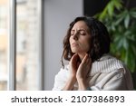 Small photo of Sick woman suffer from sore throat touch enlarged lymph nodes staying home on sick leave. Unhappy young female with coronavirus disease, angina or pharyngitis illness symptoms. Girl feeling discomfort