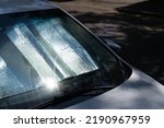 Small photo of Closeup of protective reflective surface under the windshield of the passenger car parked on a hot day, heated by the sun's rays inside car. Sunshade, Heat protection, auto accessory concept
