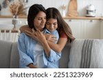 Small photo of Cute girl daughter embracing mother from behind, expressing gratitude, kid telling mom she loves her. European family mommy and child cuddling, enjoying time together at home. Mother-daughter bond