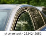Heat, high temperature concept. Closeup of slightly ajar car window for better cooling on hot summer day. Opened vehicle window for air circulation in warm weather