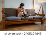 Small photo of Sad depressed woman sitting on sofa, stroking adorable breed cat Devon Rex. Lonely teen girl in need of love, friendship. Domestic animal as person helpmate, companion, friend in difficult situations