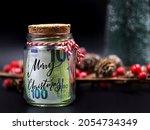 Euro money banknote in christmas jar with text merry christmas on black background with christmas decoration
