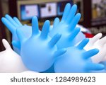 Small photo of Mumpish blue and white medical gloves. It is a lot of hands in gloves. Balls in the form of hands. Different opinions on medicine