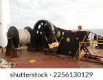 Small photo of heavy mooring winch and anchor windlass system with bow stopper at forecastle deck of a ship