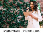 Small photo of The master of ceremonies reads a speech. woman in a white suit with a beautiful makeup