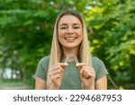 Small photo of Happy young woman is holding an invisalign bracer