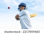 Small photo of Female Indian cricket player wearing protective gear and hitting the ball with a bat on the field