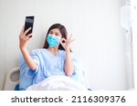 female patient being treated in hospital lying on the bed in the patient room Hold your smartphone and take a selfie. Concept of medical services in hospitals. health insurance