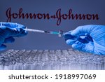 Small photo of Toronto, Ontario, Canada - February 14, 2021 : A health worker prepares to administer a shot of the American vaccine Johnson and Johnson. Name is blurry and vials containing mRNA technology vaccine.