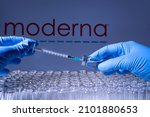Small photo of Toronto, Ontario, Canada - February 14, 2021 : A health worker prepares to administer a shot of the American vaccine Moderna. Name is blurry and vials containing messenger RNA technology vaccine.