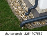 Small photo of Gutter elbow leads rainwater into the garden. Drainage system.