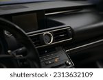 Salon of an expensive sports car. Leather seats, electronic dashboard, gear selector, pedals, leather steering wheel, tachometer, speedometer, controls.