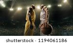 Small photo of Black basketball players on big professional arena before the game. Two teams. Players collided face to face. Player holds a ball