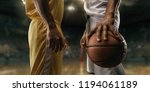 Small photo of Two black basketball players on big professional arena before the game. Two teams. Players collided face to face. Player holds a ball. Close up