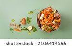 Small photo of Sorted kitchen waste in compost-bucket on green background top view. Compost-container. Sustainable life style.Vegetable, fruit peels, scraps from food preparation collected in trash-can for recycling