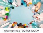 Small photo of Sorted plastic garbage. PET, PP, HDPE, LDPE stuff for recycle on blue background. Eco friendly concept. Recyclable plastic waste: bottles, containers, disposable cups, bottle caps. Empty place