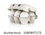 Six white chicken eggs in a paper grey crate isolated on white background