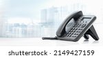 Small photo of telephone with VOIP on white table on blurred city background. customer service support, call center concept. telephone devices at office desk. Modern VoIP or IP phone.