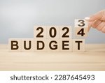 Business concept of planning 2024. Businessman flips wooden cube and changes words BUDGET 2023 to BUDGET 2024. New year business plan concept in 2024. Economy and business. Phrase 2024 BUDGET