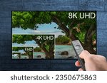 Small photo of Comparing TV resolutions on television screen. TV ultra HD resolution. 8K resolutions compare on oled tv. Watching television in TV room. Compare of television resolution. hand with remote control