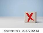 Small photo of Cross mark x on wooden cube. Rejection sign in wooden cube stack. Concept of negative decision making or choice of vote, againt, resist, contravene law, regulatory, non-compliance concept.