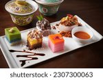 Small photo of Assorted Nyonya sweet dessert or simply known as kueh or kuih. Traditional nyonya kuih platter. Selective focus. Translation wording on the cups: longevity and good health