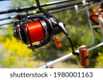Small photo of Basia Fishing Reels with red line on carp rods, on rodpod