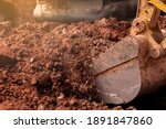 Small photo of Closeup bucket of backhoe digging the soil at construction site. Crawler excavator digging on demolition site. Excavating machine. Earth moving equipment. Excavation vehicle. Construction business.