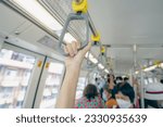 Woman hand firm grip safety handrail in elevated monorail train. Mass transit system in modern city. Inside of electric train. Tourist travel by city sky train. Public transportation. Urban transport.