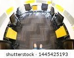 Small photo of Delhi, India - ciraca 2019: Fisheye shot of person's shoes, grey carpet and the yellow and black chairs in a seating workspace. Shows soemone coming into an office for the first time or very early or