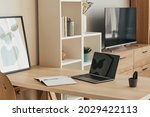 Background image of minimal home office setup with blank laptop on wooden desk in cozy apartment, copy space