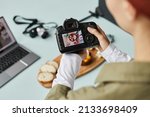 Close up of food photographer working in home studio, focus on digital camera with image on screen, copy space